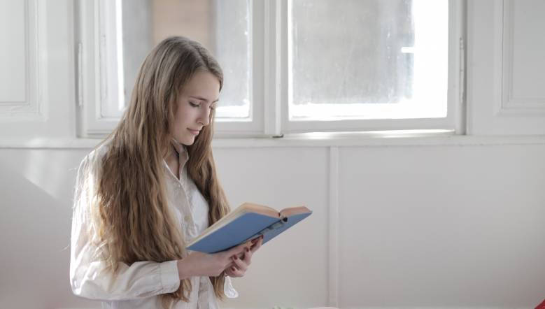 woman-in-white-long-sleeve-shirt-holding-blue-book-3830859.jpg